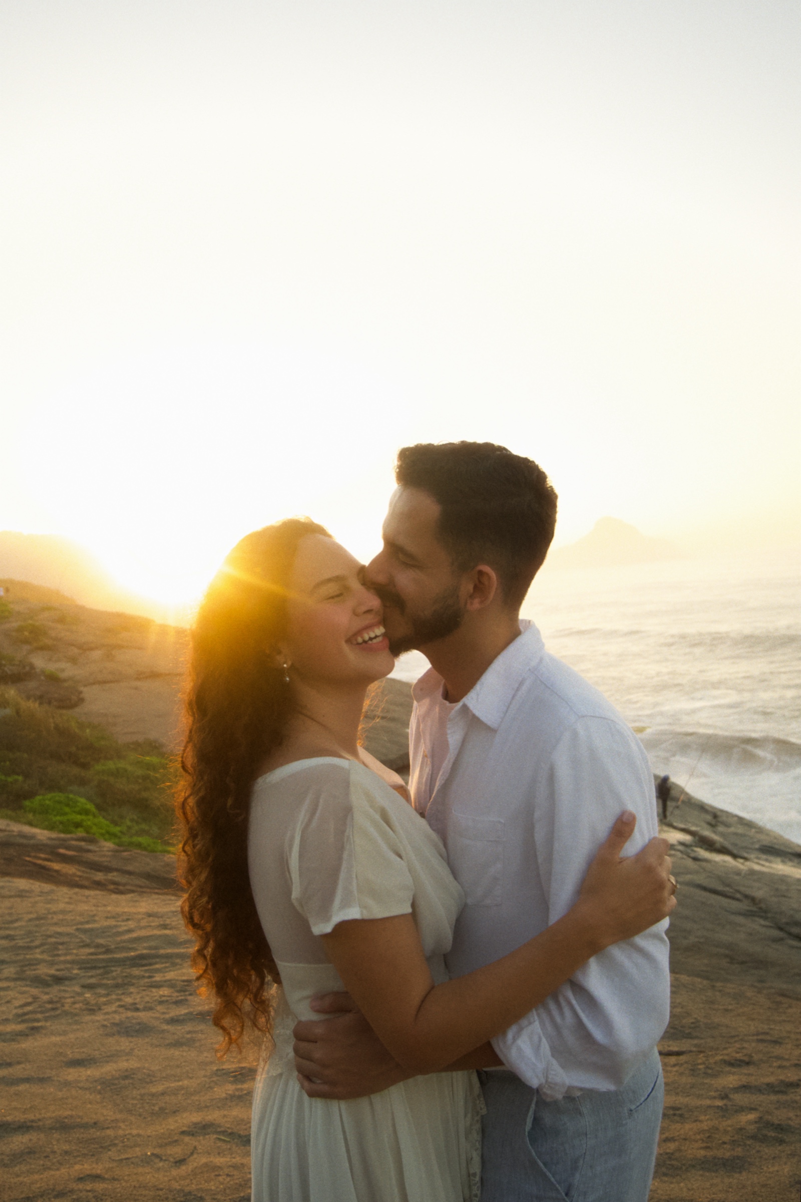 Casal abraçado ao pôr do sol na praia